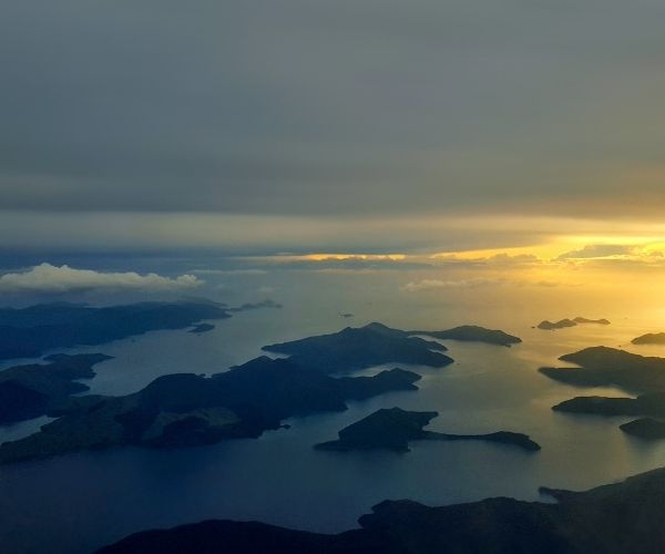 Aerial view of clouds hanging over mountains and the ocean