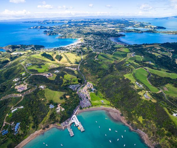 Aerial view of blue waters, yachts and a green island